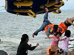 Flipping hell! Five tourists are flung through the air when 'donut boat' ride crashes into beach in Indonesia
